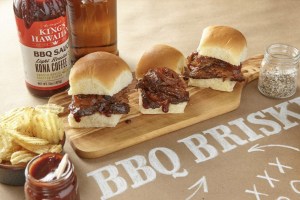 Photo of 3 brisket sliders on a wood cutting board