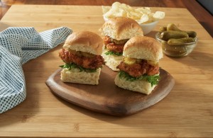 Photo of 3 hot chicken sliders on a wood board